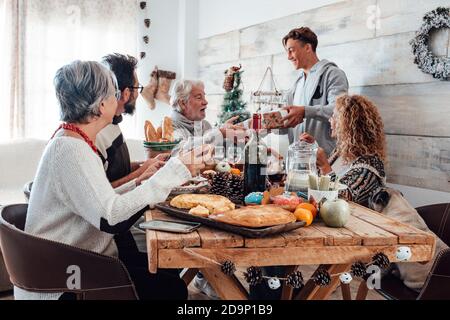 Familie genießen zusammen weihnachtsessen zu Hause - kaukasische Menschen Viel Spaß in der Freundschaft feiern Feiertage und Abend - weiß Heim und Holztisch Stockfoto
