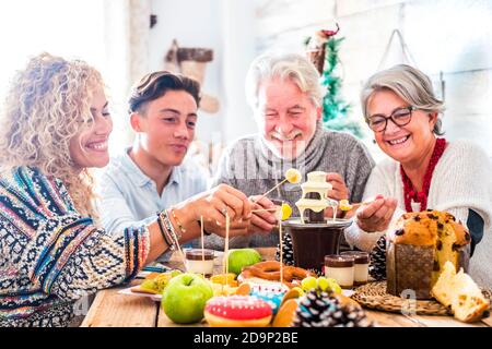 Familie mit drei Generationen genießen gemeinsam die Party zu Hause - weihnachtsschmuck und fröhliche fröhliche kaukasische Menschen mit verschiedenen Alter und Weihnachten Essen und Dekorationen auf dem Tisch Stockfoto