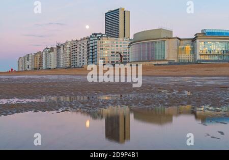 Skyline von Oostende (Oostende) mit Nordseestrand bei Sonnenuntergang und Vollmondspiegelung, Belgien. Stockfoto