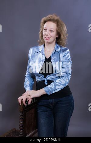Fröhliche 40 Jahre alte Frau in blauen Jeans gekleidet und azure Jacke Studio Portrait Stockfoto