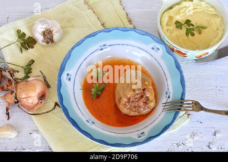 Gefüllte Paprikaschoten schlagen Reis und Hackfleisch und Maische Kartoffeln auf weißem Holzhintergrund serviert / traditionelle Balkan-Küche / Stockfoto