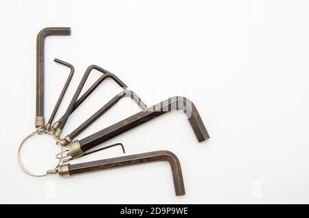 Ein Satz von Sechskantschlüsseln, die auf einem Ring auf weißem Hintergrund hängen. Stockfoto