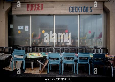 Stühle stapeln sich in einem Hamburger und Cocktail-Restaurant geschlossen wegen der Beschränkungen auferlegt, um die Ausbreitung der zweiten Welle des Coronavirus in Barcelona zu stoppen gesehen. Ausbruch des Coronavirus zweite Welle in Spanien, kovide Todesfälle in der letzten Woche kamen bei 1,002 und die Infektionsrate beginnt sich zu verlangsamen. Stockfoto