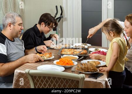 Eine Familie von Mutter, Vater, Sohn und Tochter essen zu Hause. Hausgemachtes Abendessen mit Familie und Lebensstil Stockfoto