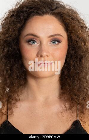 Dank der Sommersprossen ist sie eine sehr charakteristische Frau. Viel Haar in Form von Locken. Stockfoto