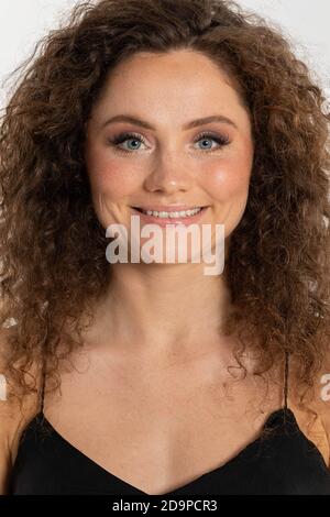 Dank der Sommersprossen ist sie eine sehr charakteristische Frau. Viel Haar in Form von Locken. Stockfoto