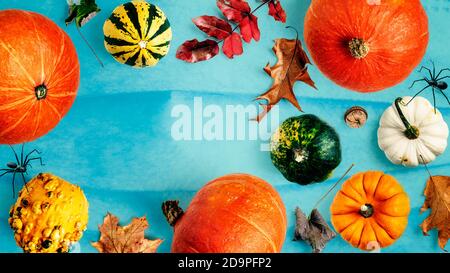 Halloween Hintergrund mit blauer medizinischer Maske. Kreatives Layout mit Kürbis, Herbstblättern und Spinnen. Urlaub, Coronavirus und Pandemievorsorge Co Stockfoto