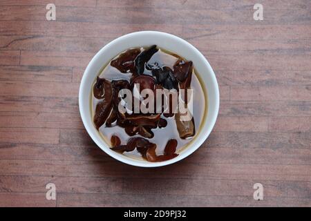 Rehydrierter Holz-Ohrpilz oder schwarzer jude-Pilz in weiß Schüssel Stockfoto