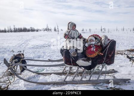 Zwei Nenzen auf einem Schlitten in einer weißen Schnee-Tundra-Landschaft, Yamalo-Nenzen Autonomous Okrug, Russland Stockfoto