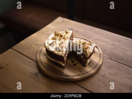 Karottenkuchen auf Couchtisch im Café. Holzbrett mit Kuchen auf. Stockfoto