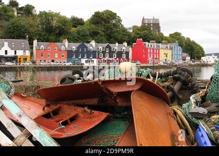 Tobermory auf der Isle of Mull, Argyll und Bute, Schottland. Die Hafenfront mit farbigen Häusern von der Hafenmauer mit Fischerausrüstung aufgestapelt. Stockfoto