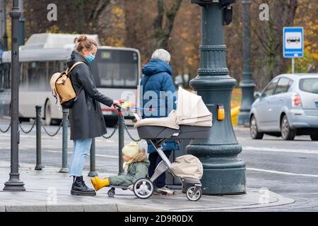 Mädchen mit Kinderwagen zu Fuß in der Stadt in der Nähe eines Geschäfts Oder ein Einkaufszentrum während des Covid- oder Coronavirus-Ausbruchs Stockfoto