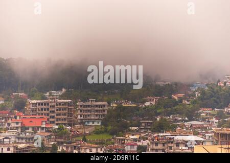 Nebel rollt in die Stadt Shillong in Meghalaya, Indien, von der anderen Seite des Berges nach einem Gewitter am Nachmittag während der Monsunsaison. Stockfoto