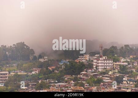 Nebel rollt in die Stadt Shillong in Meghalaya, Indien, von der anderen Seite des Berges nach einem Gewitter am Nachmittag während der Monsunsaison. Stockfoto