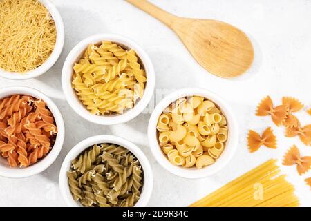 Draufsicht auf Schüsseln mit einer Auswahl ungekochter Pasta. Mediterrane Küche Stockfoto