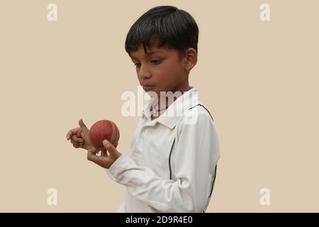 Ein Junge in Cricket Uniform gespickt Bowling Stockfoto