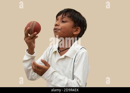 Ein Junge in Cricket Uniform pepard Bowling Bewegung Stockfoto