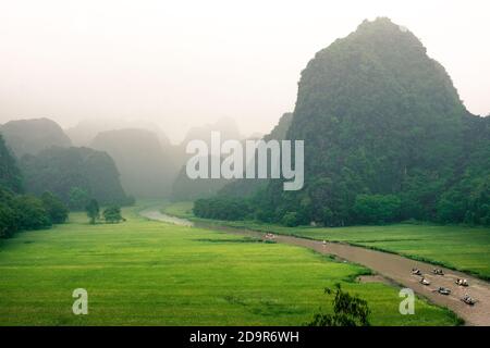 Reisfelder mit Kalksteinbergen in Tam Coc, Ninh Binh - Vietnam Stockfoto