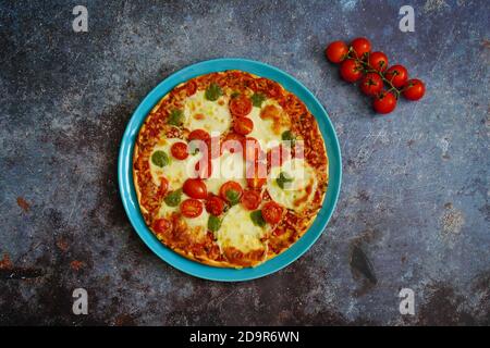 Hausgemachte Pizza mit Tomaten, Mozzarella-Käse und Basilikum-Pesto. Stockfoto