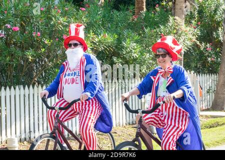 Als Onkel Sam in patriotischen Farben gekleidet fahren Fahrradfahrer während der jährlichen Parade zum Unabhängigkeitstag am 4. Juli 2019 in Sullivan's Island, South Carolina, die Straße hinunter. Die winzige wohlhabende Sea Island Beach Gemeinschaft gegenüber von Charleston veranstaltet eine übergroße Golfwagen Parade mit mehr als 75 dekorierten Karren. Stockfoto