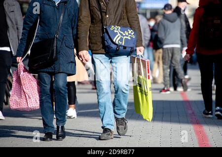 Hannover, Deutschland. November 2020. Passanten gehen mit Einkaufstaschen durch das Stadtzentrum. Nach einer Zunahme der Coronainfektionen in der Region Hannover ist es nun erforderlich, in stark frequentierten öffentlichen Bereichen Masken zu tragen. Quelle: Hauke-Christian Dittrich/dpa/Alamy Live News Stockfoto