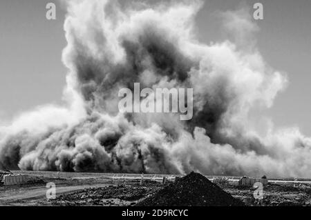 Staubwolken nach Sprengungen der Detonatoren auf dem Bergbaugelände Stockfoto