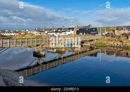 CRUDEN BAY ABERDEENSHIRE SCHOTTLAND DORFHÄUSER UND DIE HOLZBRÜCKE SPIEGELT SICH IM FLUSS CRUDEN WASSER Stockfoto