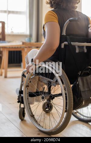 Rückansicht der jungen behinderten Frau, die im Rollstuhl sitzt Vorderseite der Kamera Stockfoto