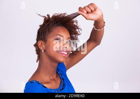 Young African American Woman machen Zöpfe, ihr krauses Afro-Haar - Menschen mit schwarzer Hautfarbe Stockfoto