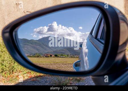 Blick auf die Landschaft und die Berge vom Seitenspiegel eines Autos, Bientina, Toskana, Italien Stockfoto