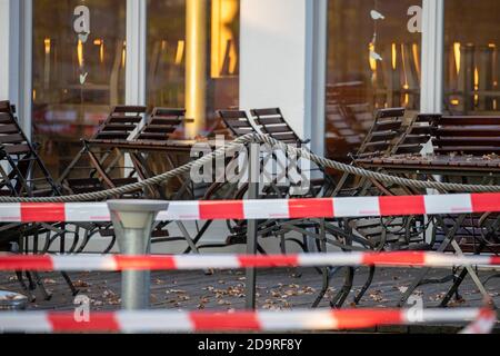 Nürnberg, Deutschland. November 2020. Tische und Stühle eines geschlossenen Biergartens sind mit einem Flatterband verschlossen. Seit Anfang der Woche ist in Deutschland eine teilweise Sperrung in Kraft. Quelle: Daniel Karmann/dpa/Alamy Live News Stockfoto