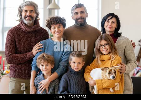 Junge große glückliche Familie von drei Generationen und niedlichen Haustier Zum Abendessen versammelt Stockfoto