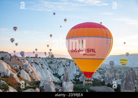 Heißluftballons fliegen über Kappadokien-Täler bei Sonnenaufgang Stockfoto