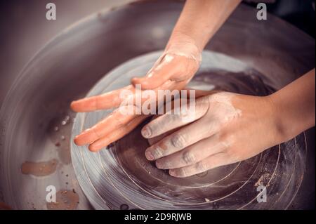 Junge Töpferin, die an einem Töpferrad arbeitet Stockfoto