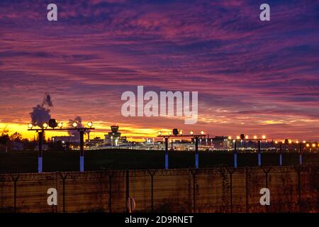 5. November 2020, Berlin, am Otto-Lilienthal-Flughafen Berlin-Tegel (IATA-Code: TXL, ICAO-Code: EDDT) die Lichter gehen langsam aus. Die letzten Starts und Landungen finden statt. Die letzte Maschine startet am Sonntag, 8. November, in Tegel. Foto am Abend mit einem schönen Abendhimmel. Im Hintergrund der rauchende Kühlturm und die Schornsteine aus dem Wärmekraftwerk Reuter West. Weltweite Nutzung Stockfoto