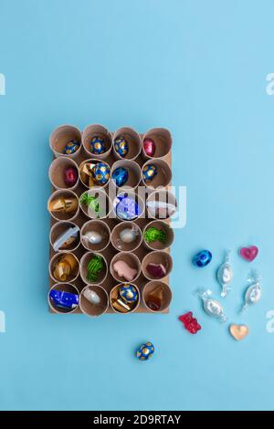 Toilettenrolle Adventskalender Handwerk, DIY, Schritt 3, Füllen mit Süßigkeiten, Draufsicht, blauer Hintergrund, Stockfoto