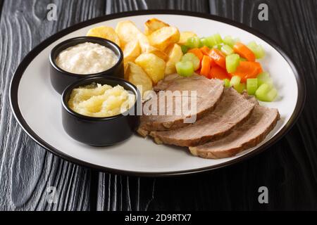 Tafelspitz Wiens Lieblingsschnitt aus gekochtem Rindfleisch mit traditionellen Begleit-Nahaufnahme in einem Teller auf dem Tisch. Horizontal Stockfoto