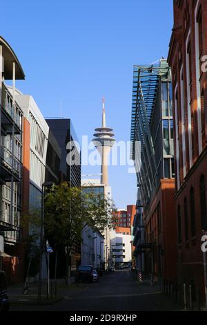 Düsseldorf (Medienhafen), Deutschland - 7. November. 2020: Blick über die Straße im Büroviertel auf Fernsehturm an sonnigen Tagen (Fokus auf Turm) Stockfoto