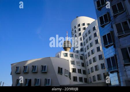 Düsseldorf (Medienhafen), Deutschland - 7. November. 2020: Blick auf Gehry Häuser mit moderner futuristischer Fassade, Fernsehturm Hintergrund Stockfoto