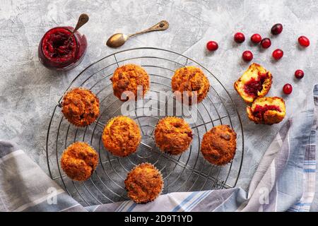 Hausgemachte Muffins mit Cranberry-Füllung, auf hellem Hintergrund. Stockfoto