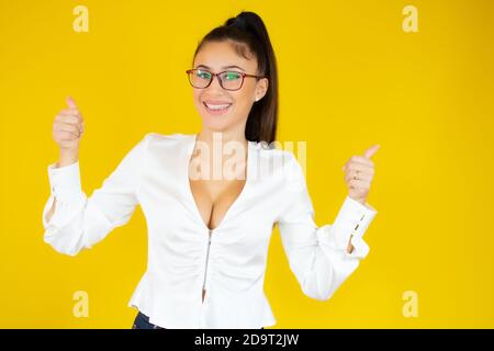 Porträt einer glücklichen jungen Geschäftsfrau mit Daumen nach oben isoliert Auf gelbem Hintergrund Stockfoto