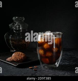 Glas Americano Kaffee gefüllt mit Eis auf dunklem Stein Hintergrund. Erfrischendes Getränk im Sommer. Stockfoto
