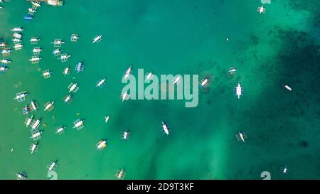 Luftaufnahme der lokalen Boote in El Nido Strand, Palawan, Philippinen. Vielen weißen Boote in der türkisfarbenen Lagune, Ansicht von oben. Stockfoto