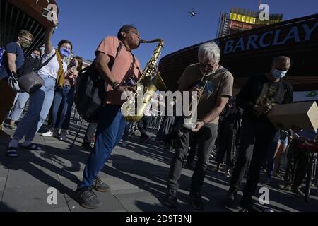 Brooklyn, New York, USA 7. November 2020. Eine improvisierte Band spielt "America the Beautiiful", während sich Menschen vor dem Barclays Center in Downtown Brooklyn versammeln, um Joe Bidens geplanten Sieg im US-Präsidentschaftsrennen zu feiern Stockfoto