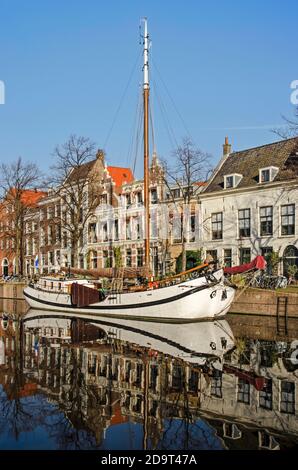 Schiedam, Niederlande, 7. November 2020: Weißes historisches Segelboot, das an einem sonnigen Tag am Kanal lange Haven (Long Harbour) festgemacht wurde Stockfoto