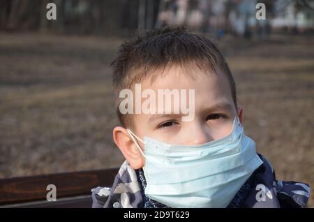 Portrait des Brünetten Mannes in einem chirurgischen Verband auf dem Hintergrund eines modernen Gebäudes, Coronavirus, Krankheit, Infektion, Quarantäne, medizinische Maske Stockfoto