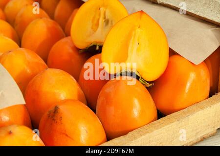 Frische Bio reife Kaki in einer Holzkiste vor dem Versand auf den Markt. Stockfoto