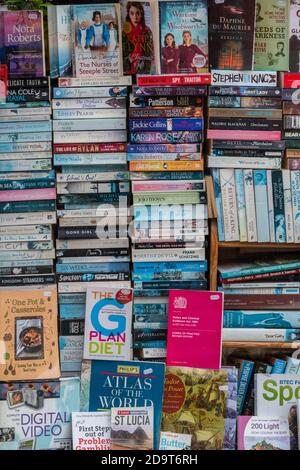 Stapel und Stapel von Taschenbüchern im Fenster einer gebrauchten Buchhandlung. Stockfoto