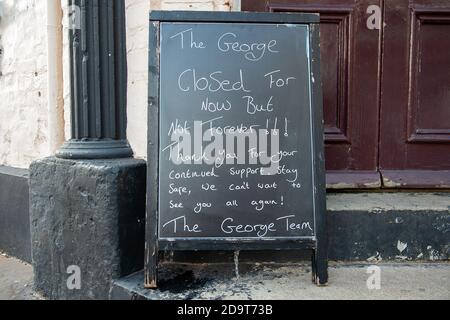 Eton, Windsor, Berkshire, Großbritannien. November 2020. Ein temporäres Schließschild vor dem George Pub in der Eton High Street. Das gute Wetter brachte heute am dritten Tag der zweiten Covid-19-Sperre viele Menschen nach Eton. Die meisten Geschäfte und Pubs in Eton sind vorübergehend geschlossen, aber einige Geschäfte wie Cafés und Restaurants sind gesetzlich erlaubt, während der letzten zweiten Covid-19 nationalen Sperre in England für Take Aways offen zu bleiben. Quelle: Maureen McLean/Alamy Live News Stockfoto