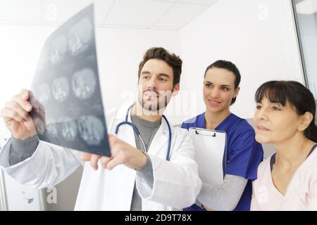 Arzt Krankenschwester und weibliche Patientin im Büro suchen eine Röntgenaufnahme Stockfoto